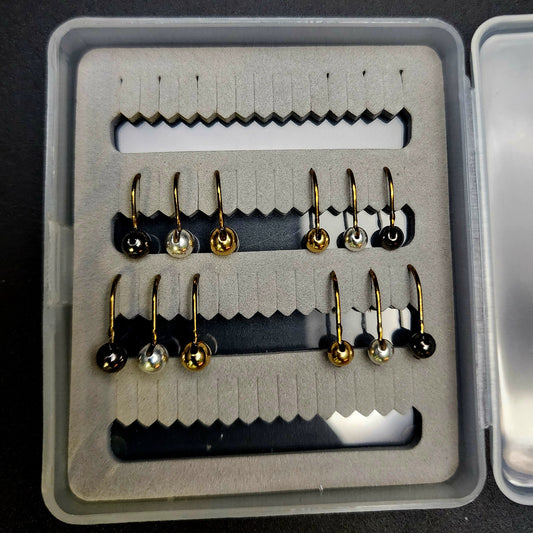 Set of fishing hooks in a box on a black background