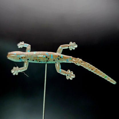 Glowing lizard-shaped lure on a black background