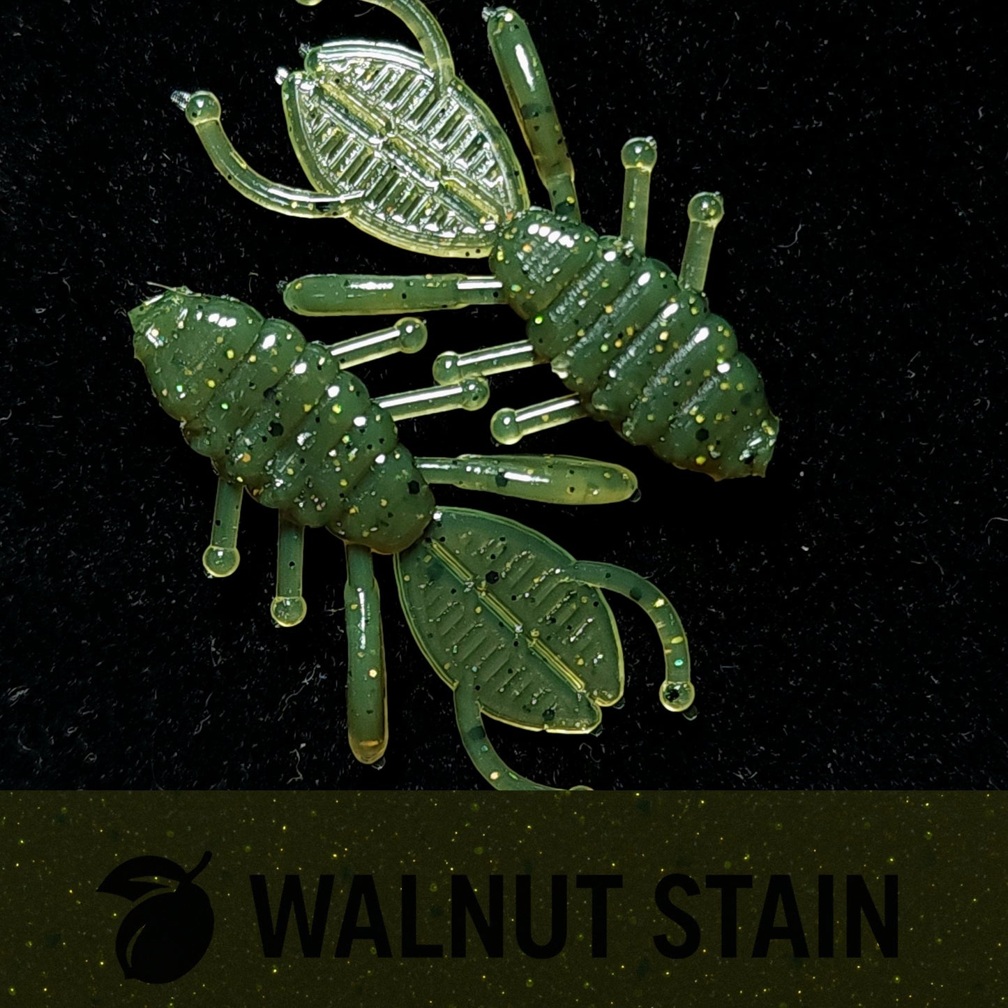 Two green insect-shaped lures on a black background with 'Walnut Stain' text.