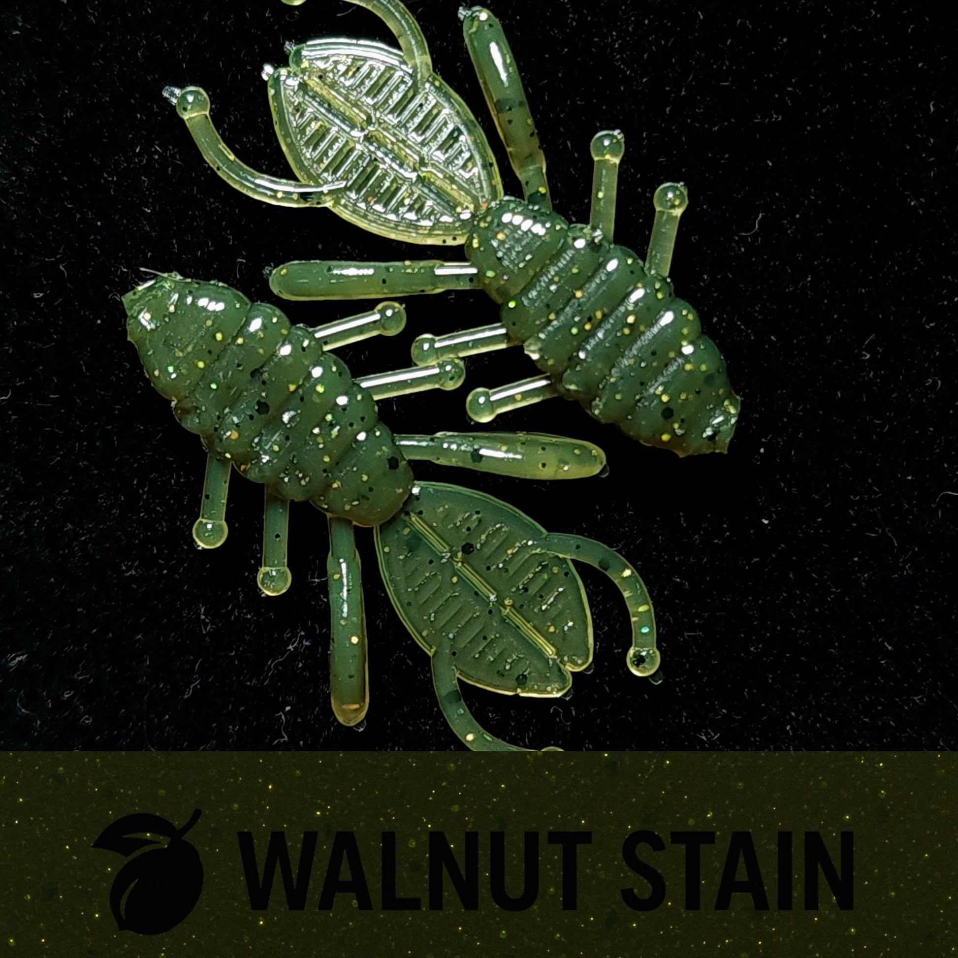 Two green insect-shaped lures on a black background with 'Walnut Stain' text.