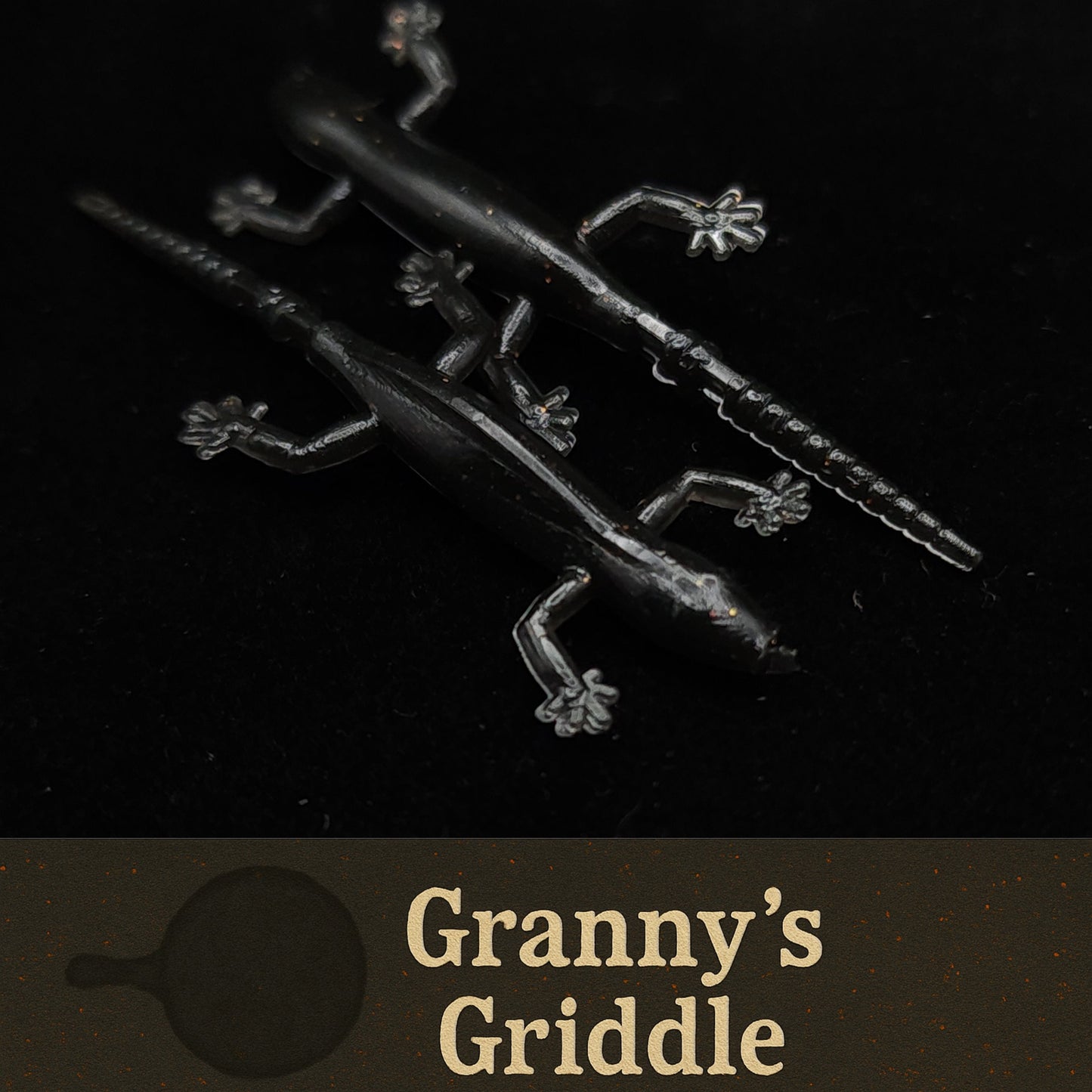 Metallic griddle with decorative handles on a black background, featuring 'Granny's Griddle' branding.