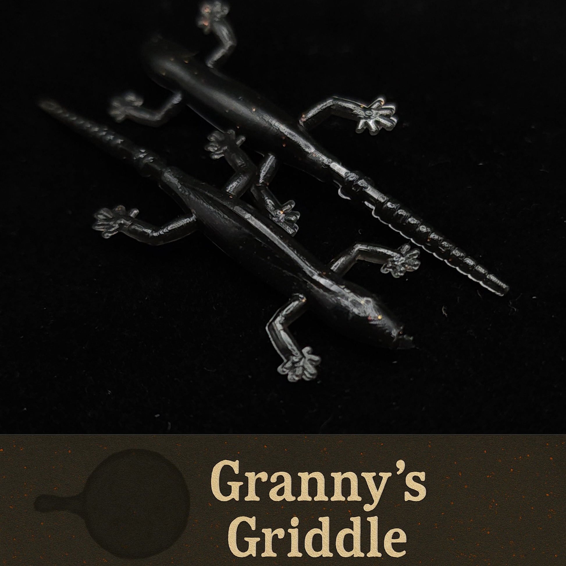 Metallic griddle with decorative handles on a black background, featuring 'Granny's Griddle' branding.