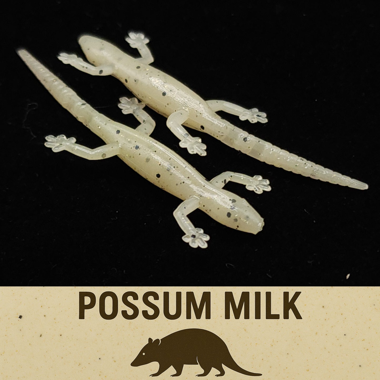 Two gecko-shaped lures with 'Possum Milk' text on a black background
