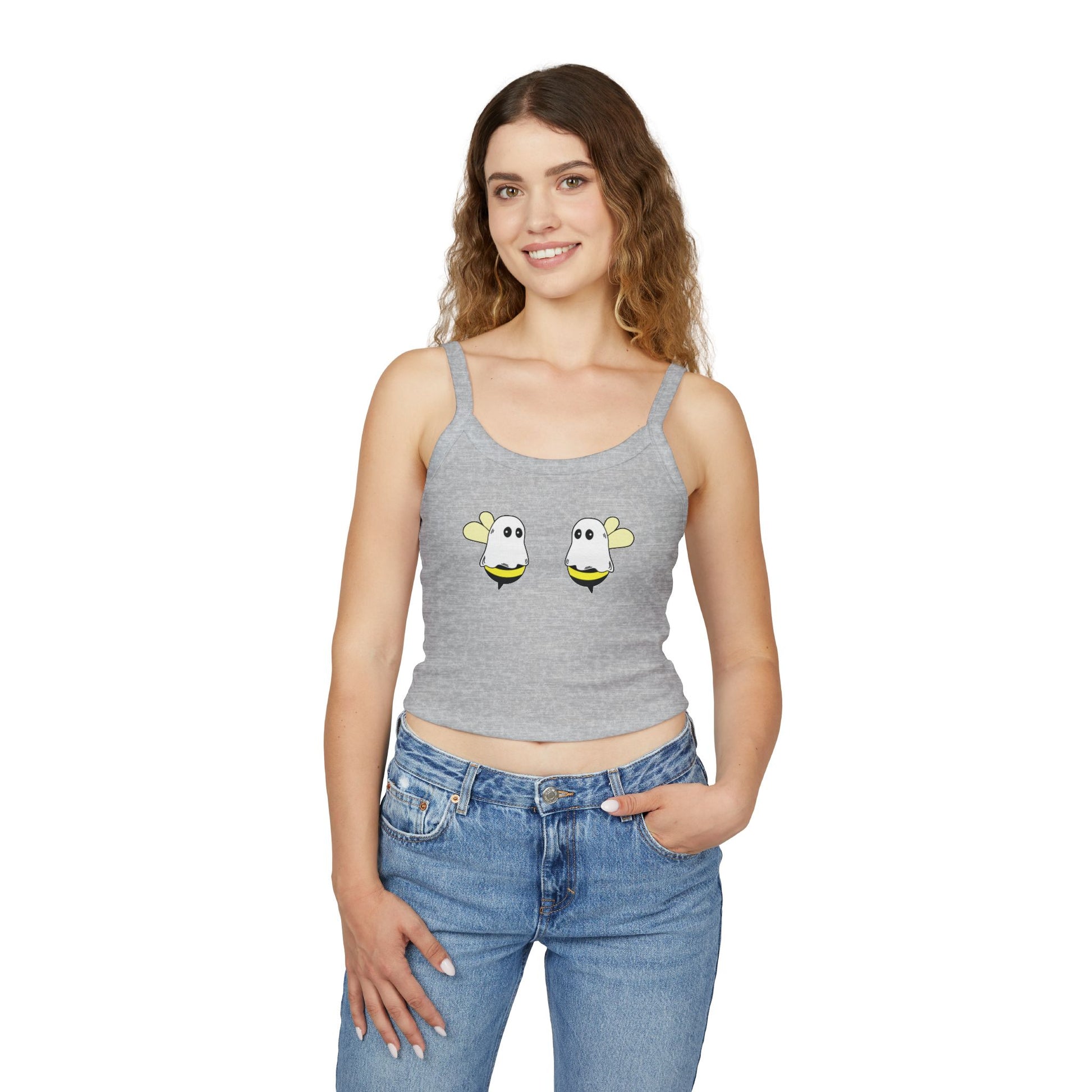 Woman wearing a gray tank top with cartoon bee designs and blue jeans on a white background